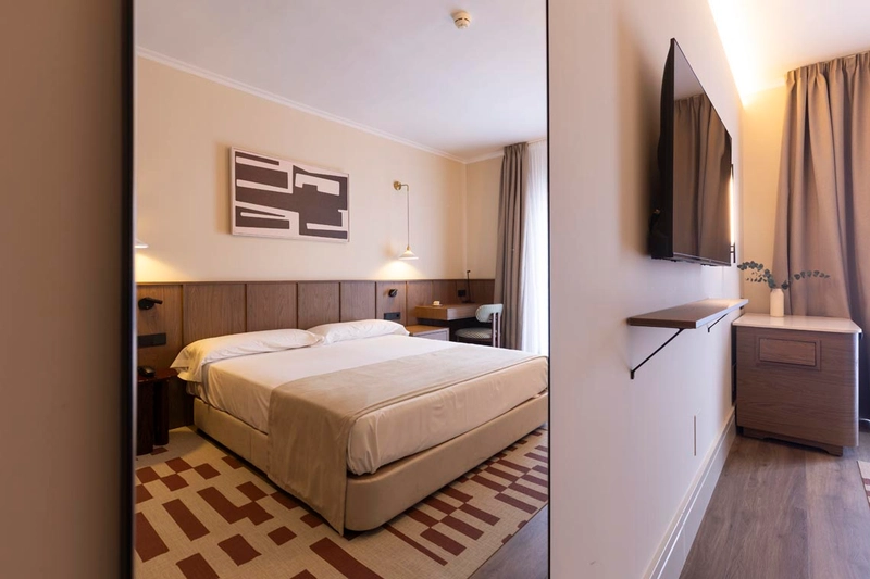 Cama y TV de pantalla plana en habitación de hotel, ideal para tu Hotel Palacio Valderrabanos.