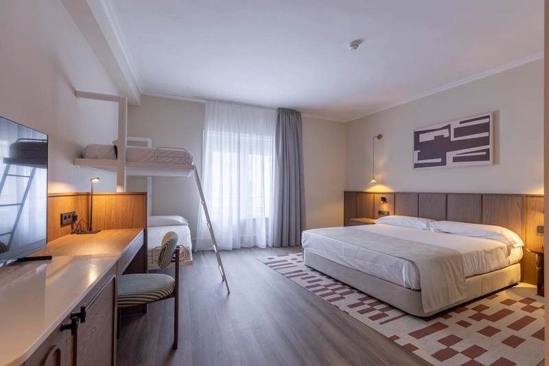 Habitación familiar de hotel con litera y cama doble, ideal para tu Hotel Palacio Valderrabanos.