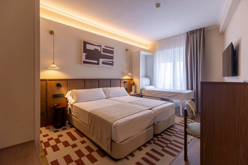 Doble habitación con cama confortable yHotel Palacio Valderrabanos con un diseño moderno y luminoso.