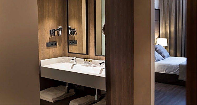 Baño moderno con doble lavabo y espejo, junto a una habitación del Palacio Valderrabanos.