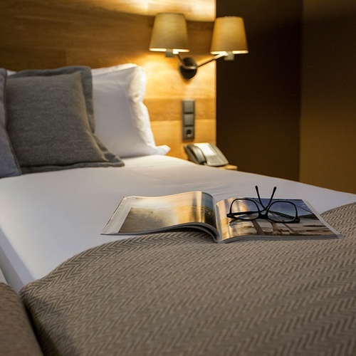 Cama de hotel com livro e óculos em Vale d Azenha.