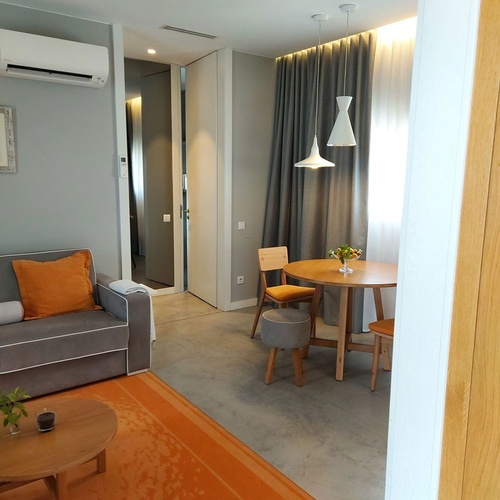 Quarto de hotel moderno em Vale d'Azenha com sala de estar e área de jantar.