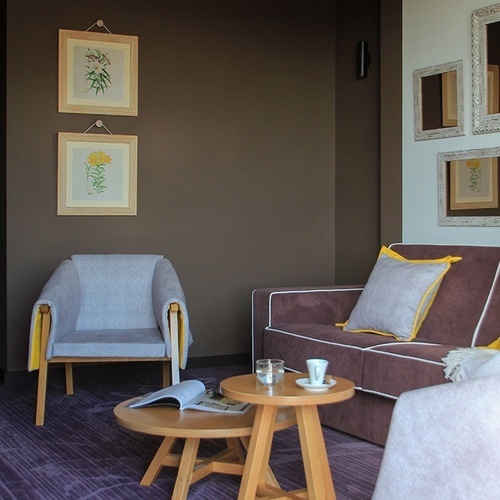 Sala de estar aconchegante em Vale d'Azenha com poltrona, sofá e mesas de centro.
