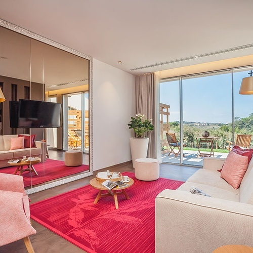 Suite em Vale d'Azenha com sofá confortável, mesa e vista para a paisagem.