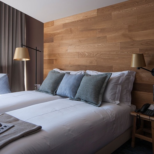 Quarto duplo moderno na Vale d'Azenha com cabeceira em madeira e ambiente acolhedor.