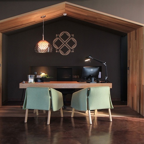 Recepção contemporânea no Vale d Azenha com mesa de madeira, cadeiras verdes e lustre.