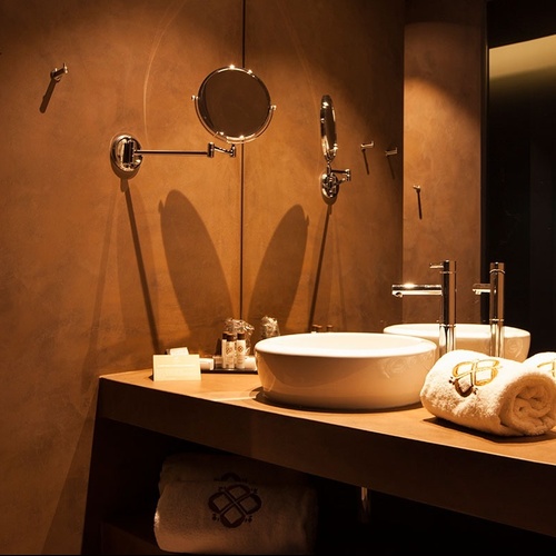 Luxuoso banheiro no Vale d'Azenha com pias modernas e toalhas bordadas.