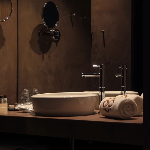 Elegante casa de banho em Vale d'Azenha com lavatório, torneiras modernas e espelhos.