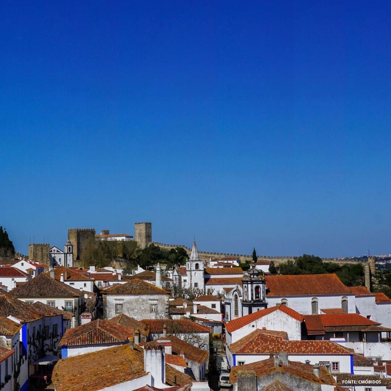 Hotel Vale d Azenha com vista para o castelo e telhados ao pôr do sol.