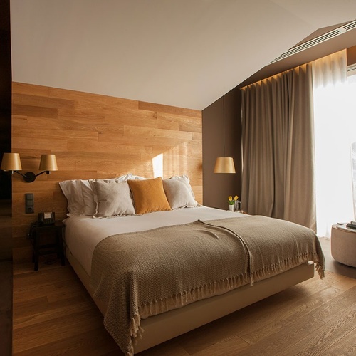 Quarto acolhedor no Vale d Azenha com parede de madeira e luz natural.