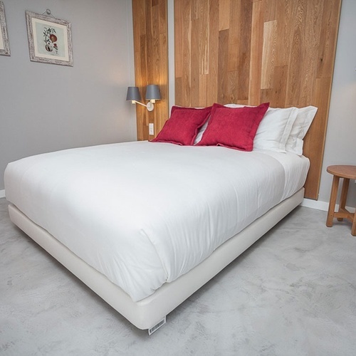 Quarto moderno em Vale d'Azenha com cama branca e almofadas vermelhas.
