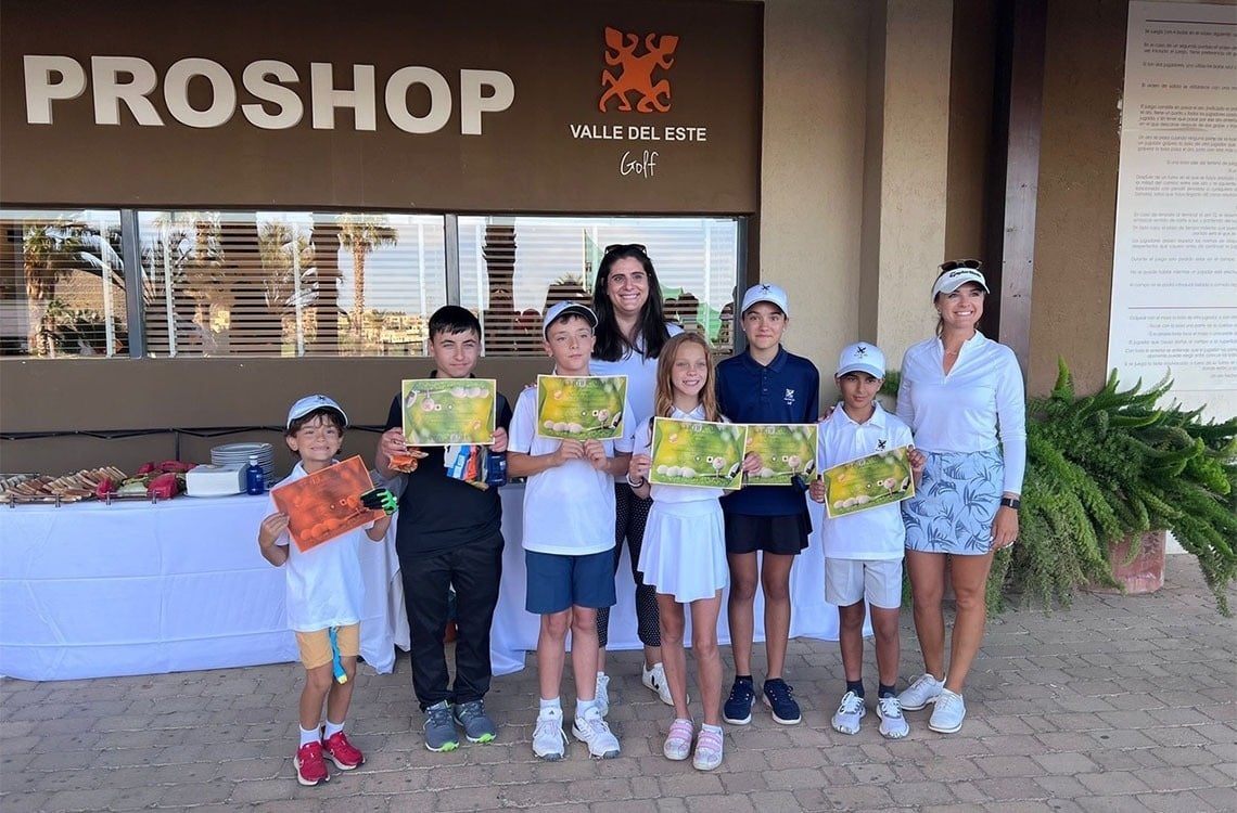 un grupo de niños posando para una foto frente a la tienda proshop