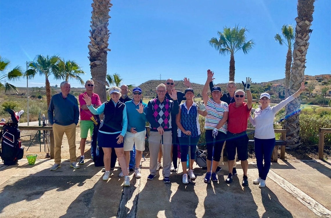 un grupo de golfistas posando para una foto en un campo de golf