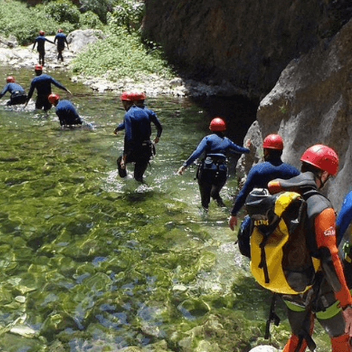eine Gruppe von Menschen geht durch einen Fluss