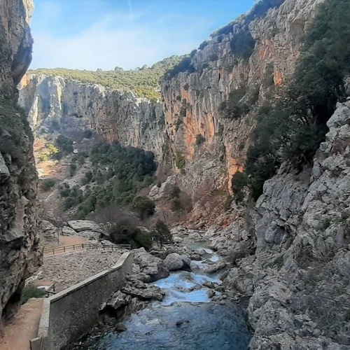 a river runs through a canyon between two rocky cliffs