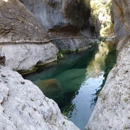 un río que fluye a través de un cañón rodeado de rocas
