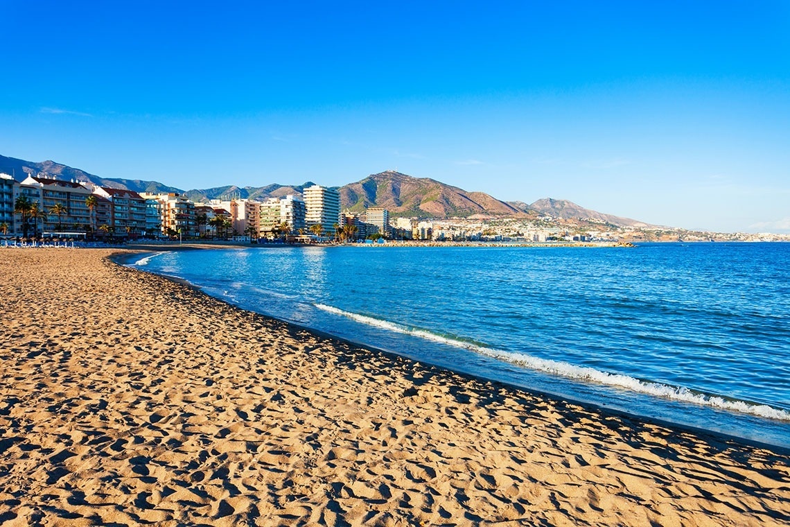 un bote verde y blanco con torremolinos escrito en el costado