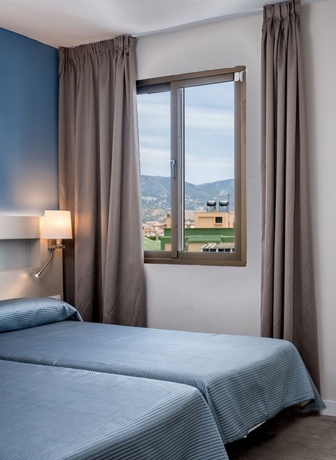 un dormitorio con dos camas y un armario blanco