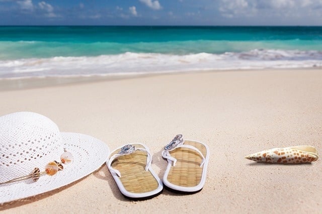 un par de sandalias y un sombrero en la playa