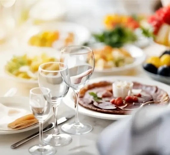 a table with plates of food and wine glasses on it .