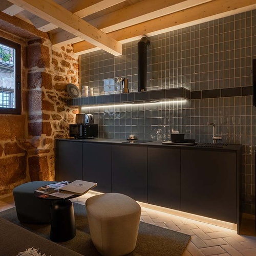 Apartamentos Vilafames Antic Palau: Modern kitchen and cozy living area with fireplace.