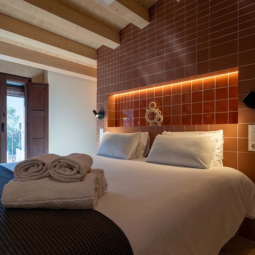 Cozy bedroom in Apartamentos Vilafames Antic Palau with comfortable bed and balcony.