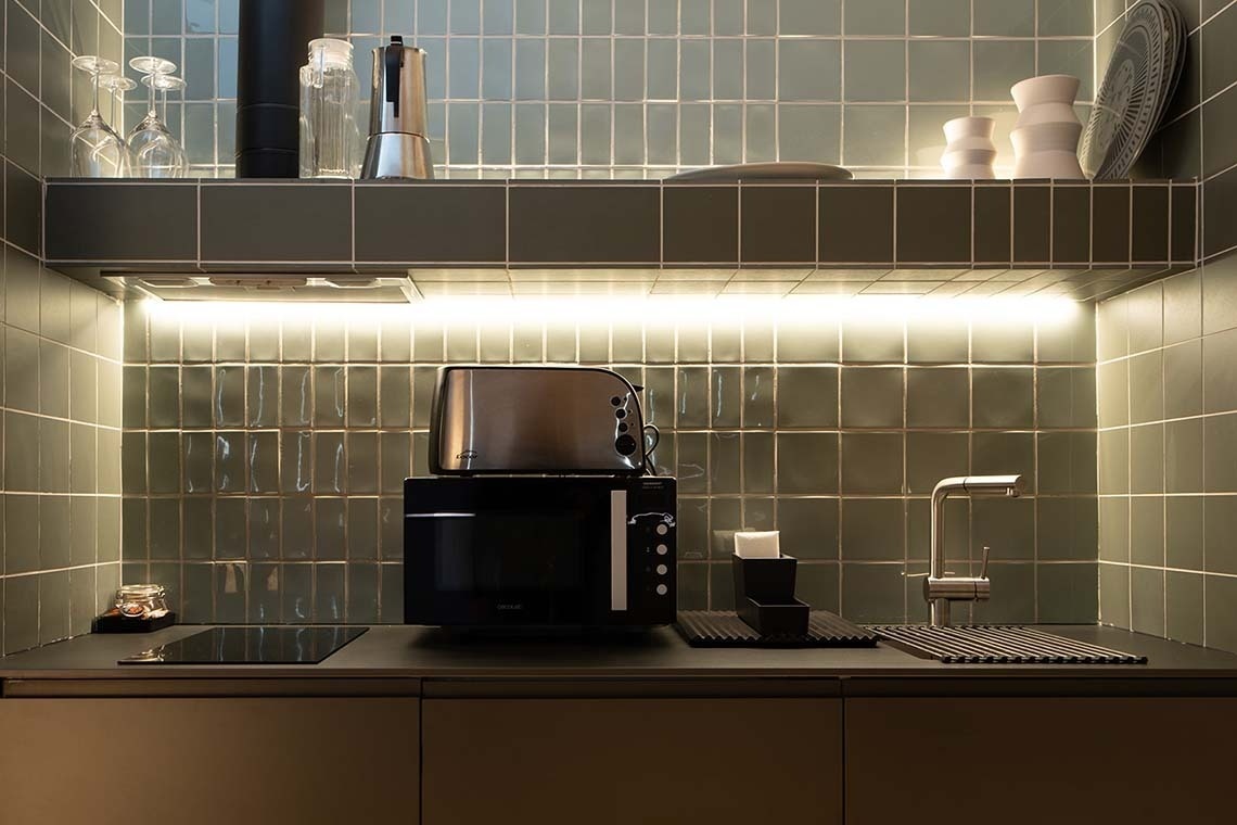 Cocina moderna en Apartamentos Vilafames Antic Palau con microondas, tostadora y grifo.