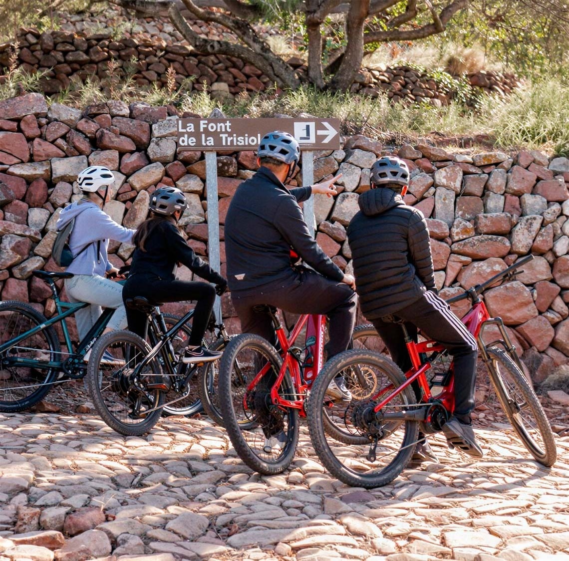 Ciclistas junto a señal de senderismo cerca de Apartamentos Vilafames Antic Palau.