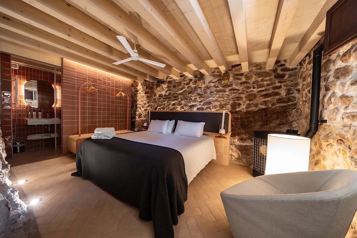 Acogedora habitación en Apartamentos Vilafames Antic Palau con cama, chimenea y baño.