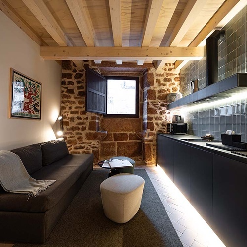 Apartamentos Vilafames Antic Palau: Cozy living room with modern kitchen & rustic charm.