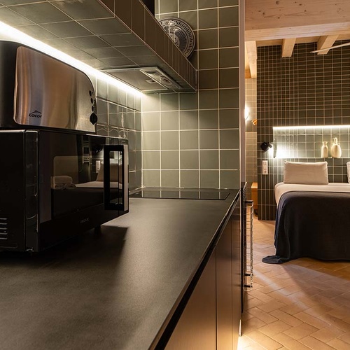 Modern room in Apartamentos Vilafames Antic Palau with kitchenette and bed. Luxury.