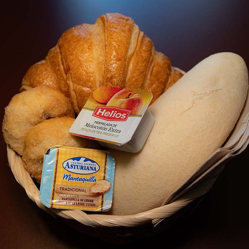 Breakfast basket at Apartamentos Vilafames Antic Palau: croissant, bread, butter, and jam.