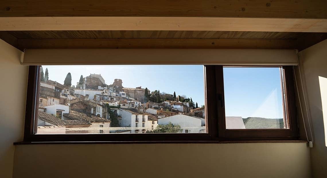 Vistas desde Apartamentos Vilafames Antic Palau a pueblo blanco con castillo y montañas.
