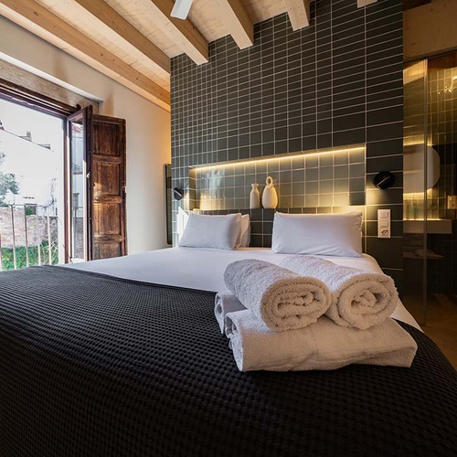 Cozy room at Apartamentos Vilafames Antic Palau with balcony and modern bathroom.