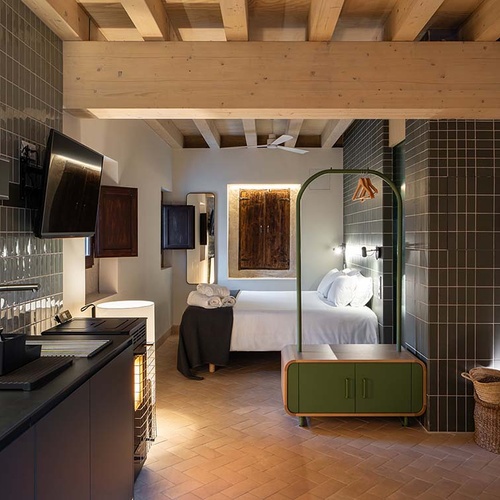 Apartamentos Vilafames Antic Palau: modern kitchen and cozy bedroom with wooden beams.
