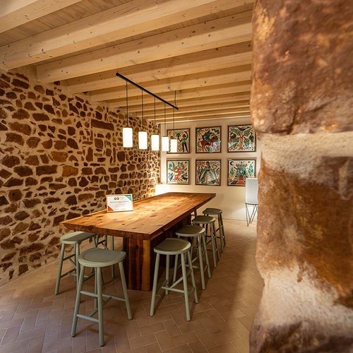 Rustic dining area with artwork at Apartamentos Vilafames Antic Palau.