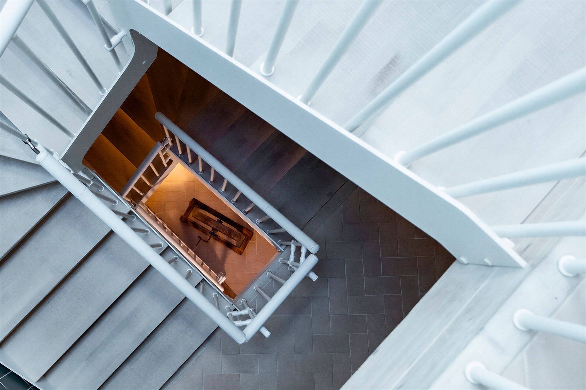 Modern white spiral staircase, leading to apartments at Offers | Apartments Antic Palau | Vilafamés, Castellón.