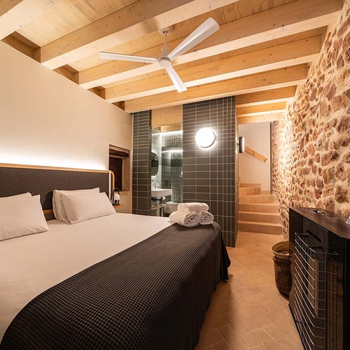 Cozy bedroom in Apartamentos Vilafames Antic Palau with fireplace and open bathroom.