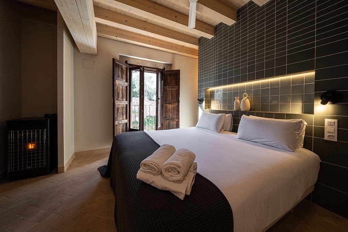 Habitación rústica con cama doble y vistas a Vilafames Antic Palau.