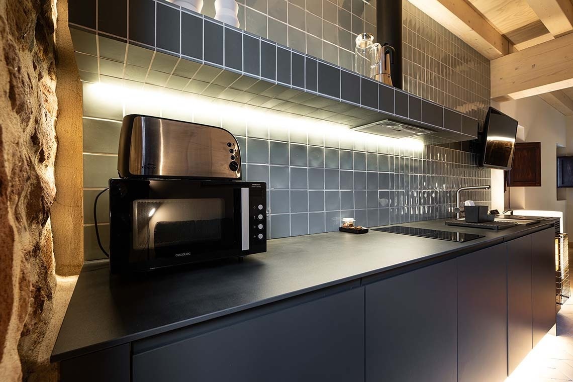 Cocina moderna en Apartamentos Vilafames Antic Palau con microondas y tostadora.