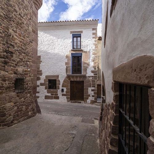 Traditional street at Apartamentos Vilafames Antic Palau, rustic facade.