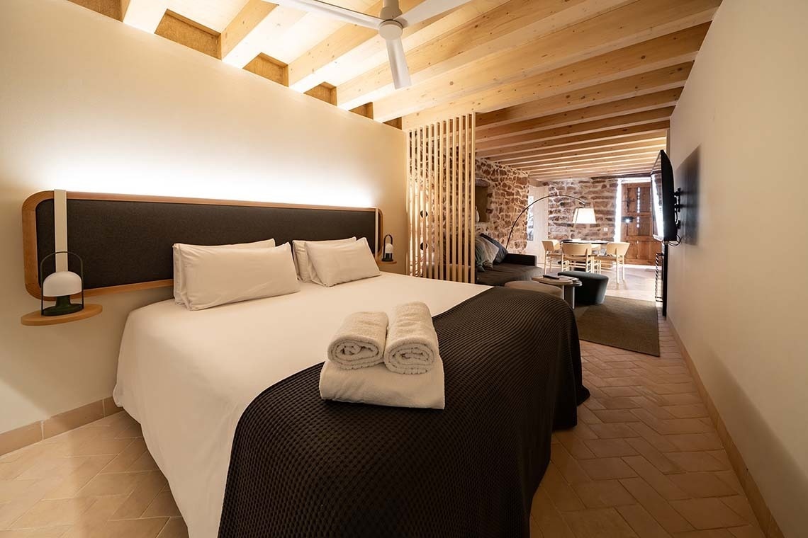 Habitación moderna con cama, sala de estar y cocina en Apartamentos Vilafames Antic Palau.