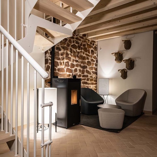 Cozy living area in Apartamentos Vilafames Antic Palau with fireplace and staircase.