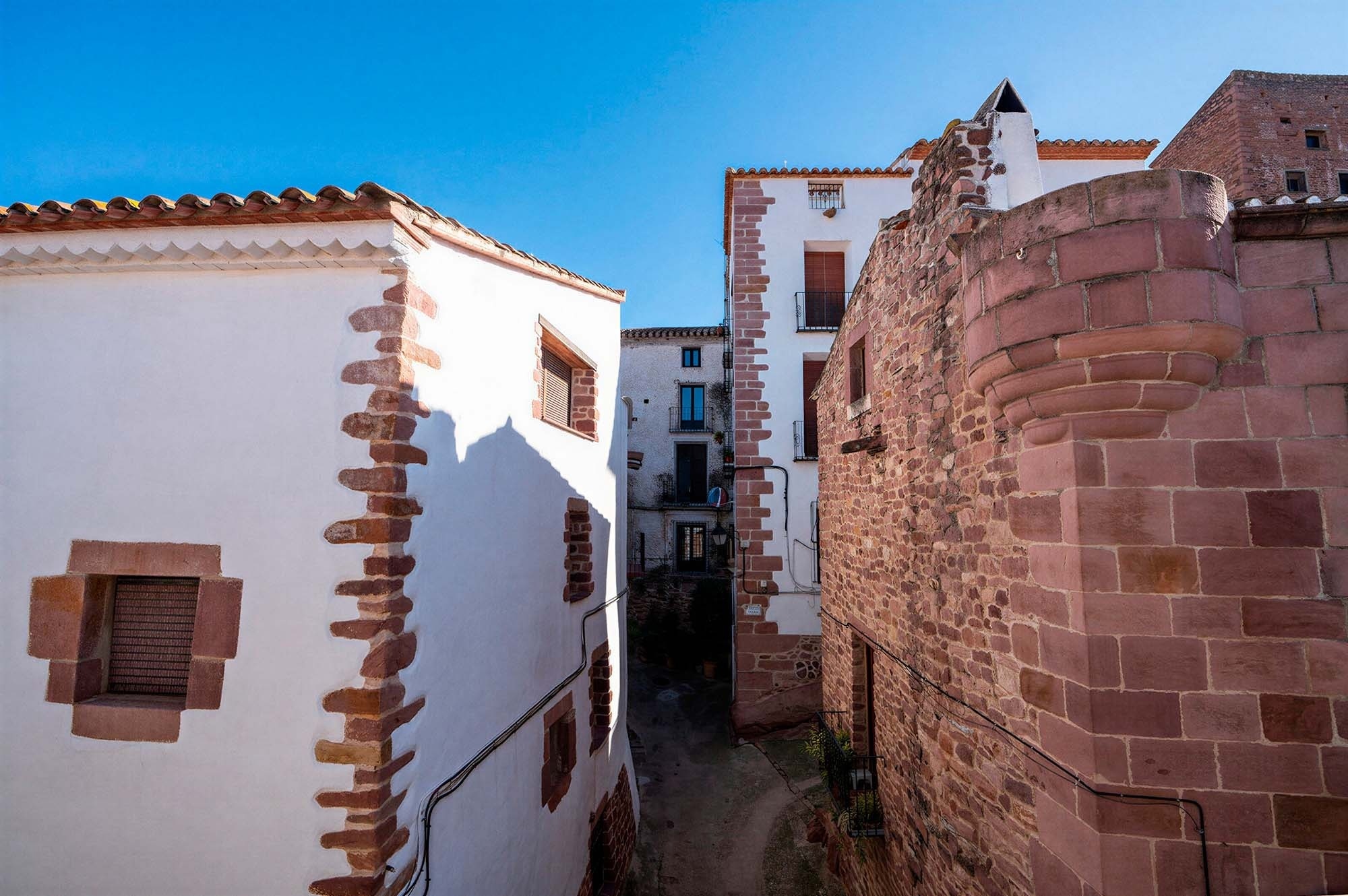 Charming old town alleyway with stone buildings. Experiences | Apartments Antic Palau | Official Website.