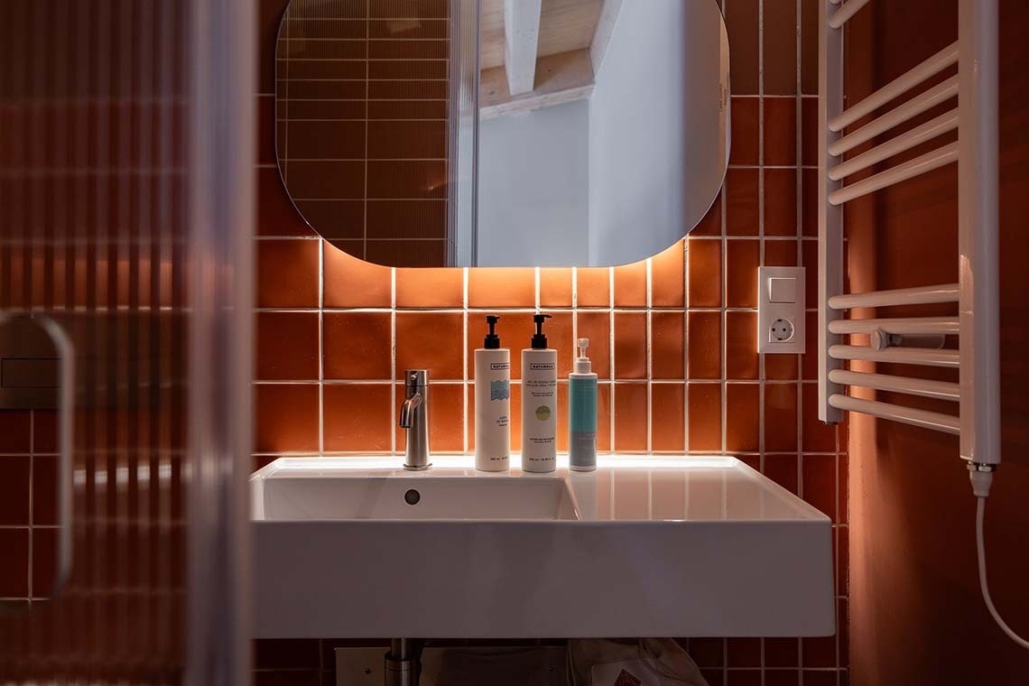 Baño moderno en Apartamentos Vilafames Antic Palau con azulejos terracota y lavabo.