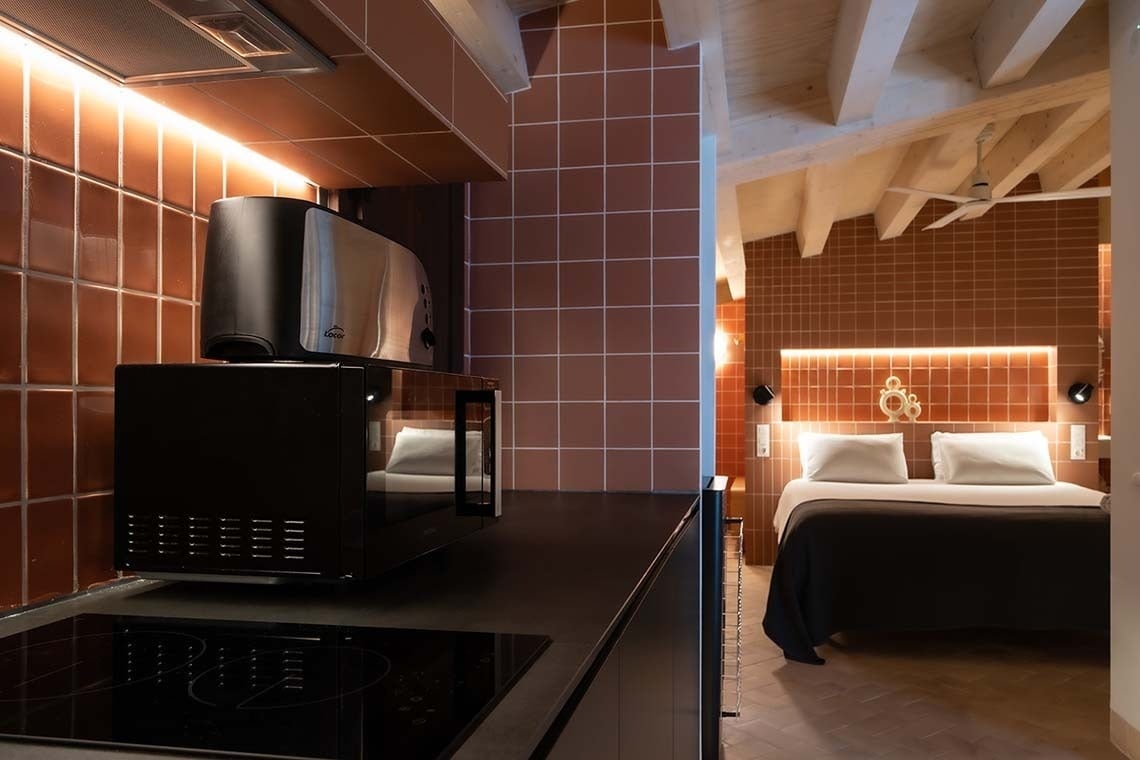 Apartamento Vilafames Antic Palau: cocina moderna y cama acogedora.