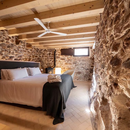 Rustic room at Apartamentos Vilafames Antic Palau featuring stone walls and wooden beams.