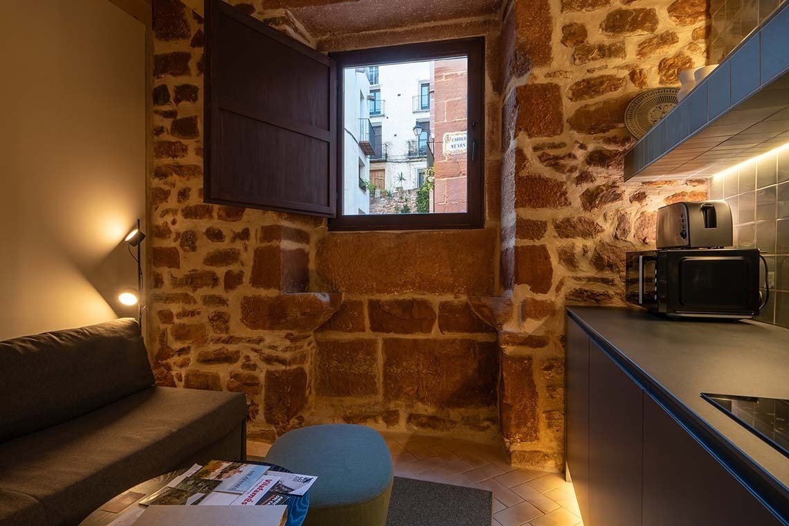 Acogedor apartamento en Vilafames Antic Palau con cocina moderna y paredes de piedra.