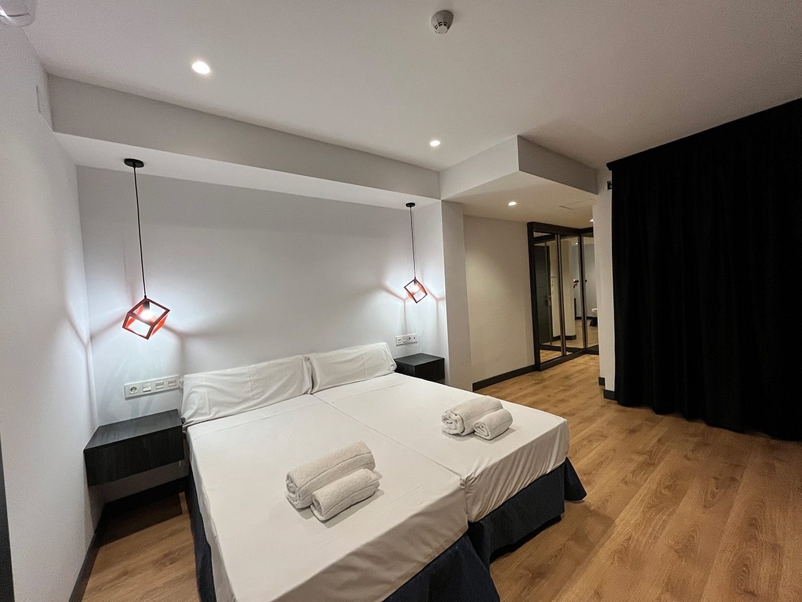 una habitación con una cama y dos mesitas de noche