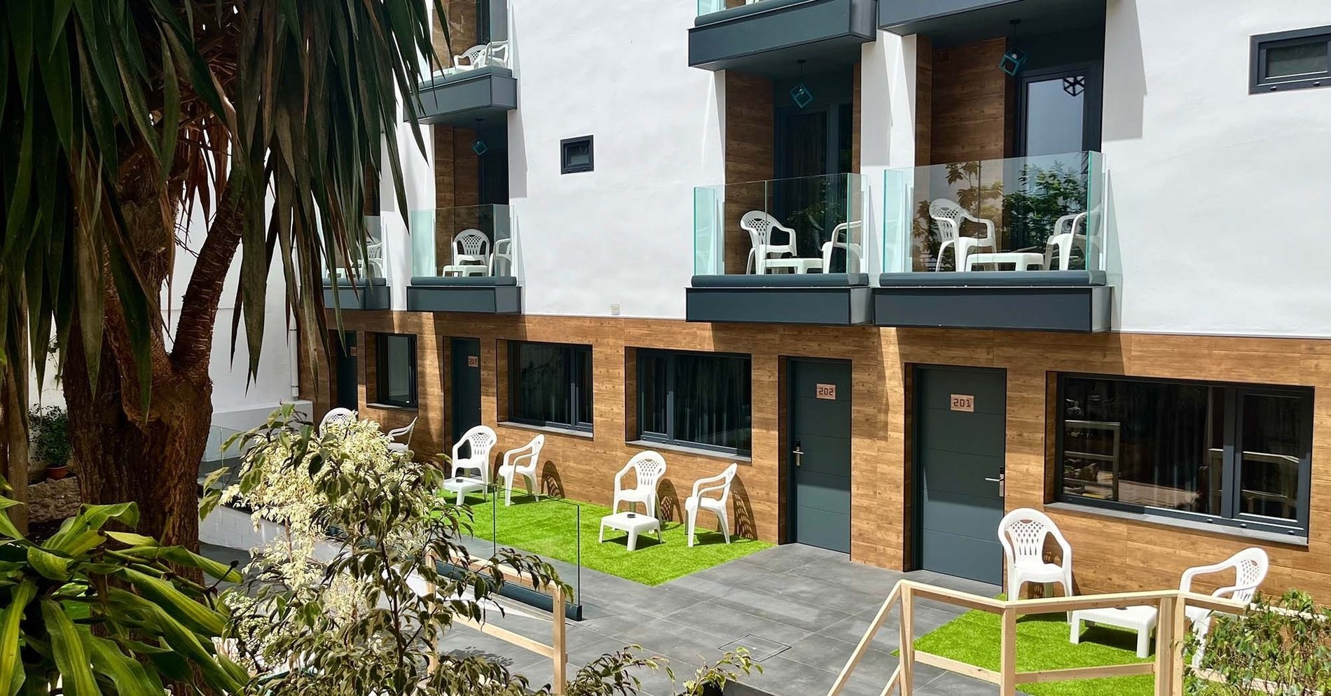 un edificio de apartamentos con balcones y sillas